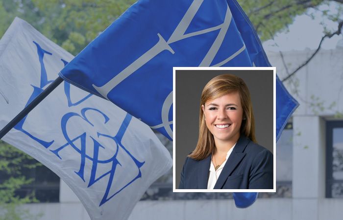 En kvinna ler med blåa flaggor i bakgrunden, relaterat till skidbudget.